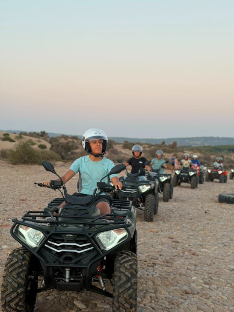 Grand groupe de touristes sur des quads orange et verts sur la plage